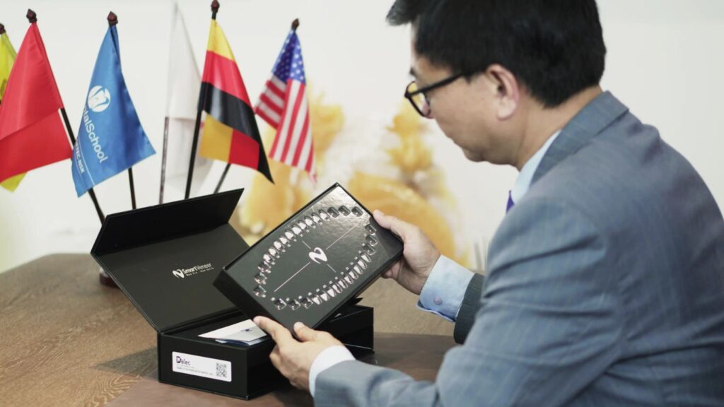 Person holding a dental veneer kit with flags in the background.
